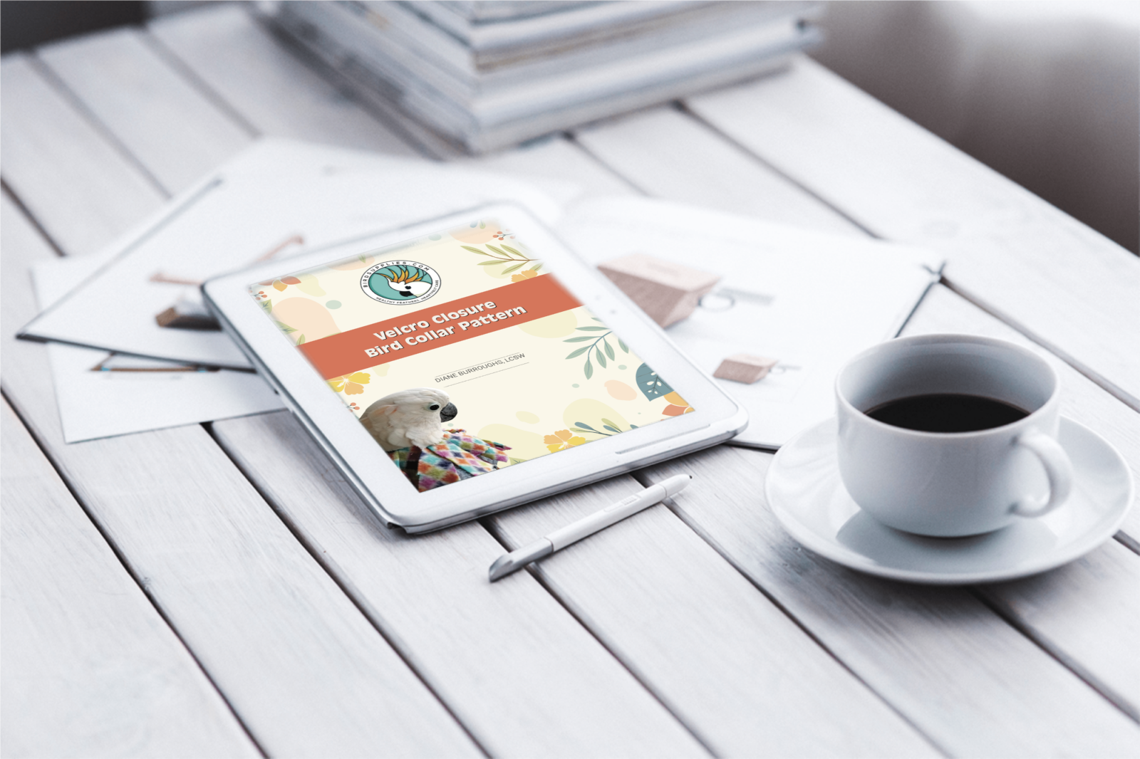 Tablet displaying DIY Velcro Bird Collar Pattern with coffee on desk.